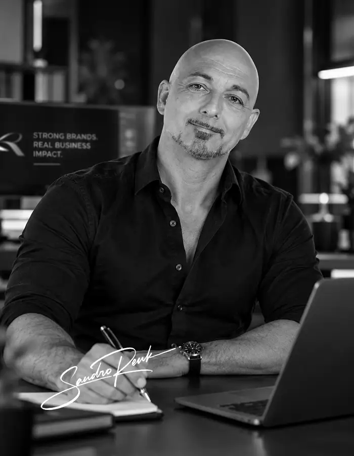 Sandro Renk, Agenturinhaber für Webdesign und Brand Building, arbeitet an einem Notebook am Schreibtisch